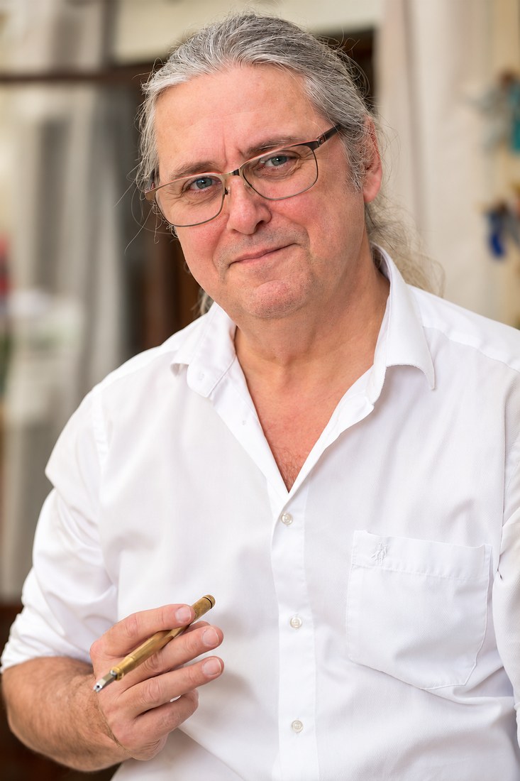 Alain Boursier, artisan verrier des Verres de Moisenay, tenant un coupe-verre
