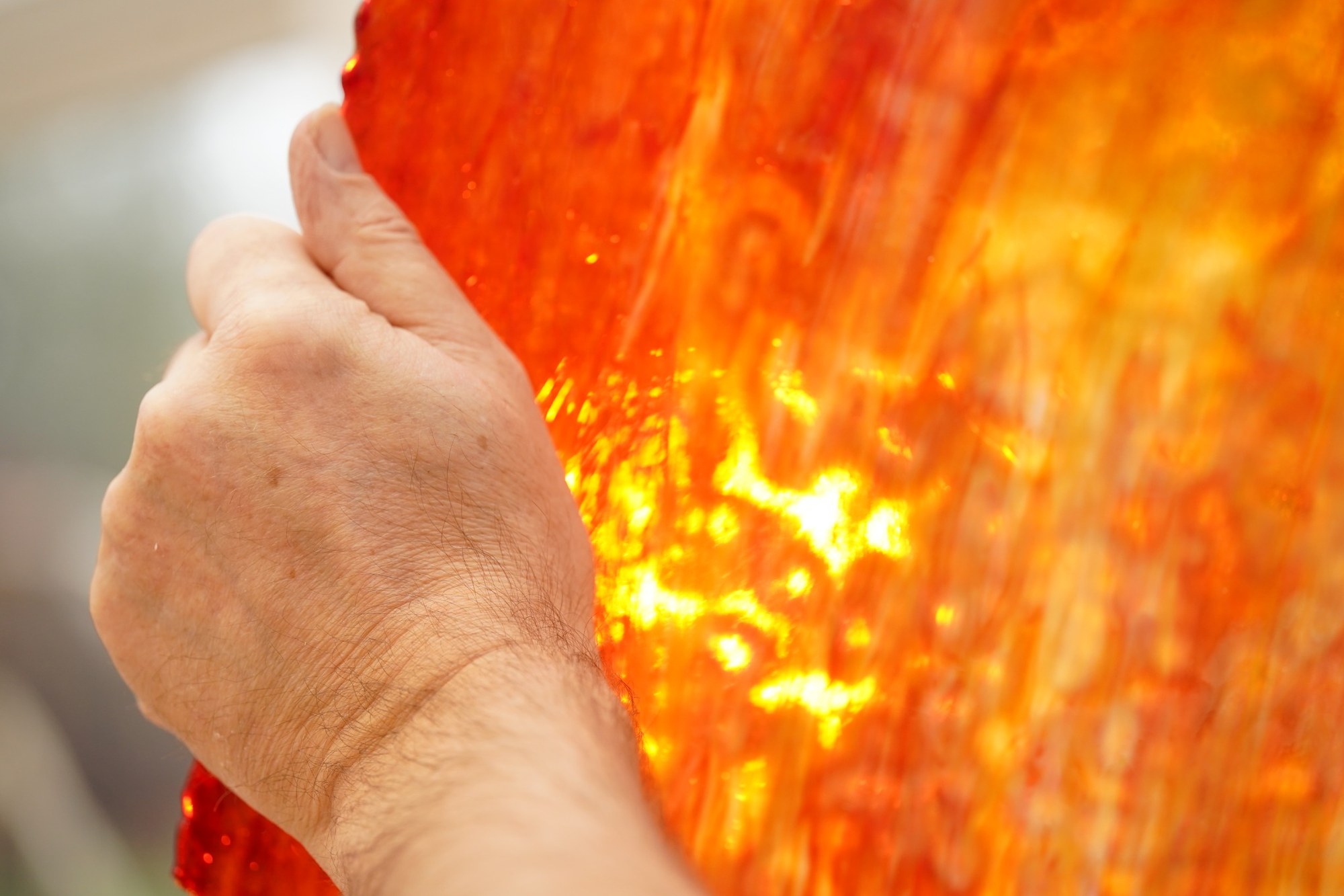 Gros plan d’un verre orange traversé par la lumière