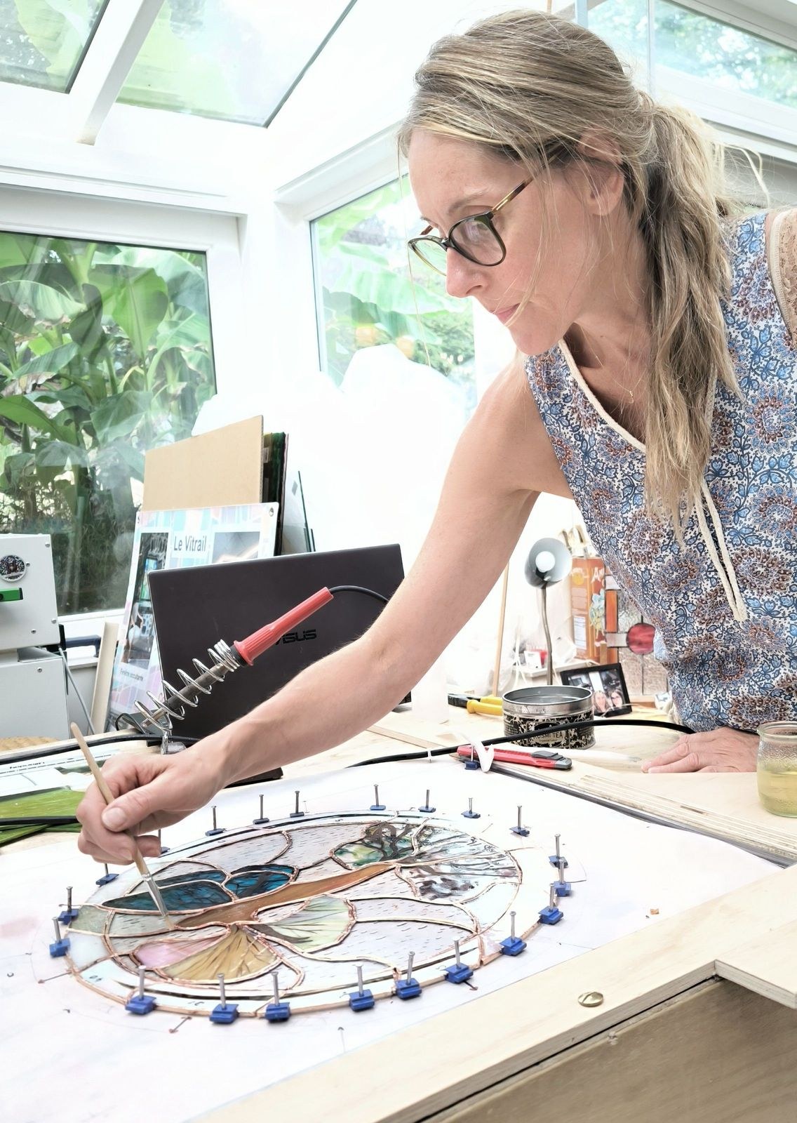 Participante réalisant elle-même son projet de vitrail à l’atelier